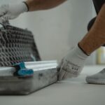Een professional repareert een beschadigde troffelvloer met aandacht voor detail en veiligheid.