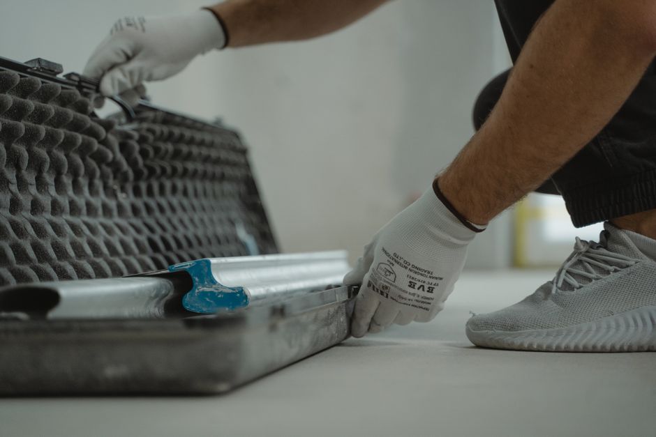 Een professional repareert een beschadigde troffelvloer met aandacht voor detail en veiligheid.